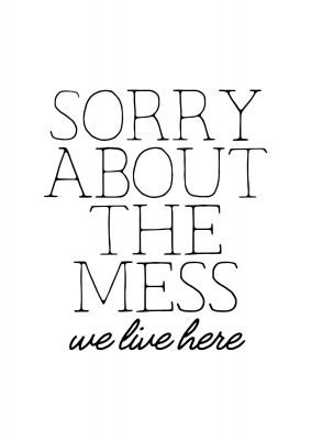 An unframed print of sorry about the mess quote in typography in white and black accent colour