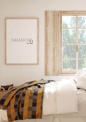 An unframed print of namastay in bed funny slogans in typography in white and black accent colour