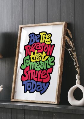 An unframed print of be the reason that someone smiles today quote in typography in white and multicolour accent colour