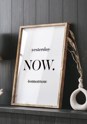 An unframed print of now quote in typography in white and black accent colour