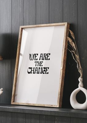 An unframed print of we are the change quote in typography in white and black accent colour