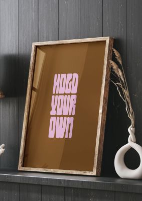 An unframed print of hold your own quote in typography in brown and pink accent colour