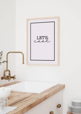 An unframed print of lets cook kitchen graphical in typography in pink and black accent colour