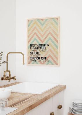 An unframed print of remember cuddles in the kitchen lyrics maps in typography in beige and multicolour accent colour